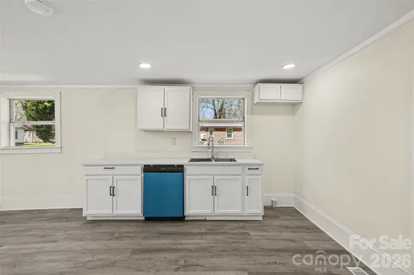 a kitchen with a sink cabinets and wooden floor