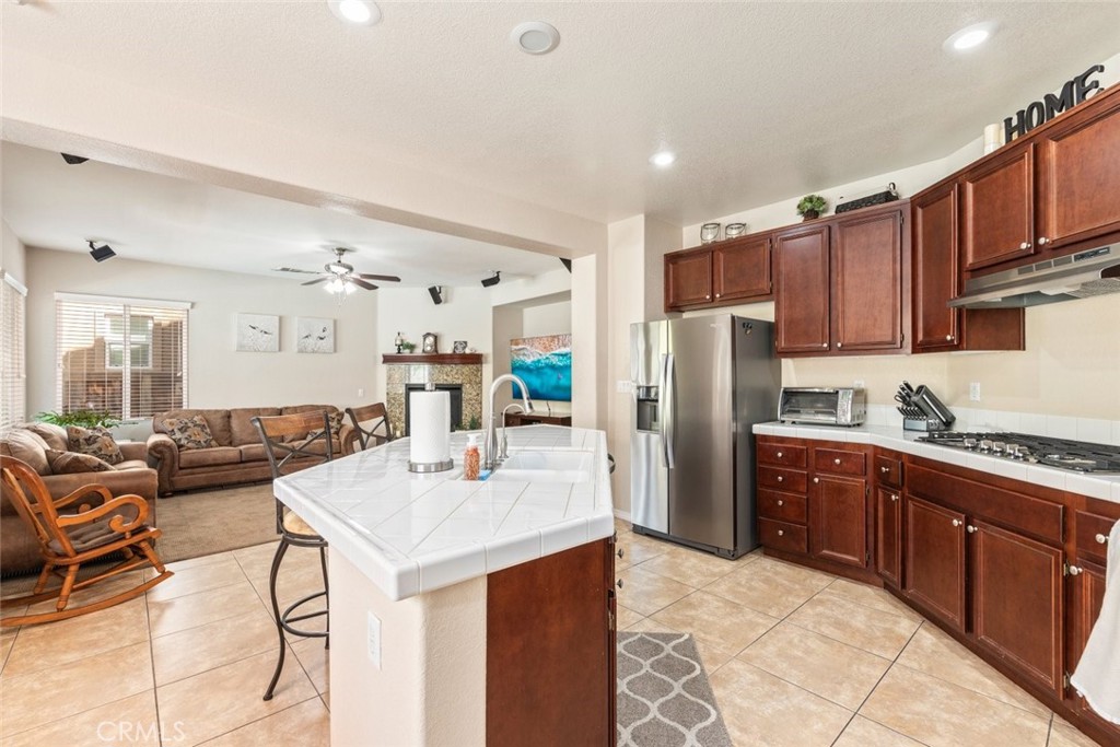46123 Drymen Avenue Temecula, CA 92592 - Photo 17 of 42 a kitchen with stainless steel appliances kitchen island granite countertop a refrigerator and a stove top oven