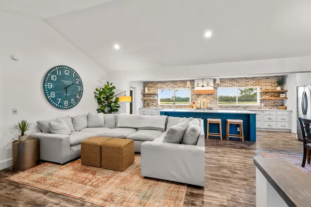 a large kitchen with a sink and wooden floor
