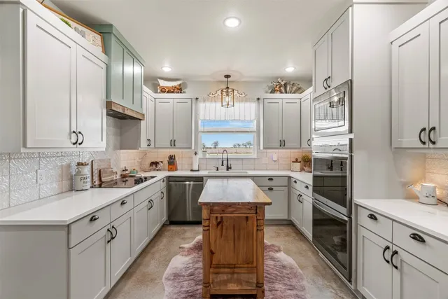 a kitchen with stainless steel appliances a sink stove and cabinets