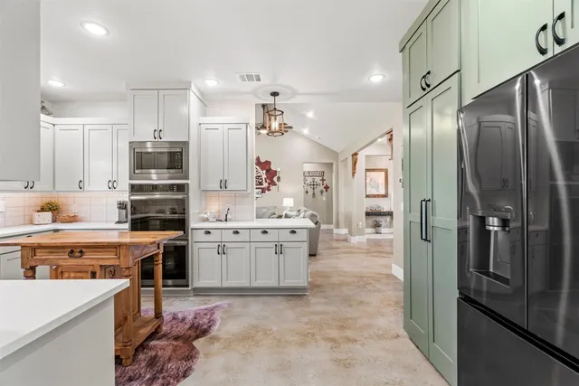 a large kitchen with a large counter top appliances and cabinets