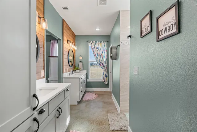 a bathroom with a double vanity sink mirror and shower