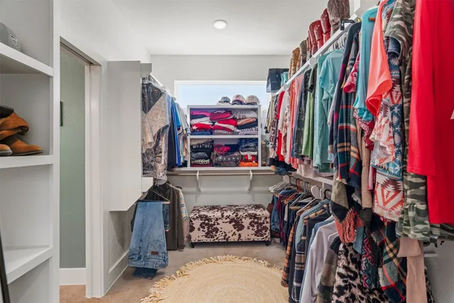 a view of walk in closet with clothes