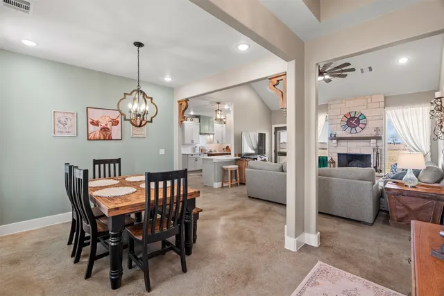a view of a dining room and livingroom with furniture wooden floor a chandelier