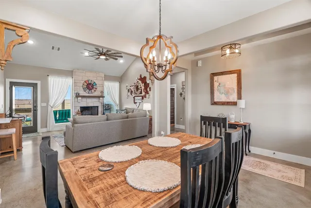a dining room with furniture a chandelier and wooden floor