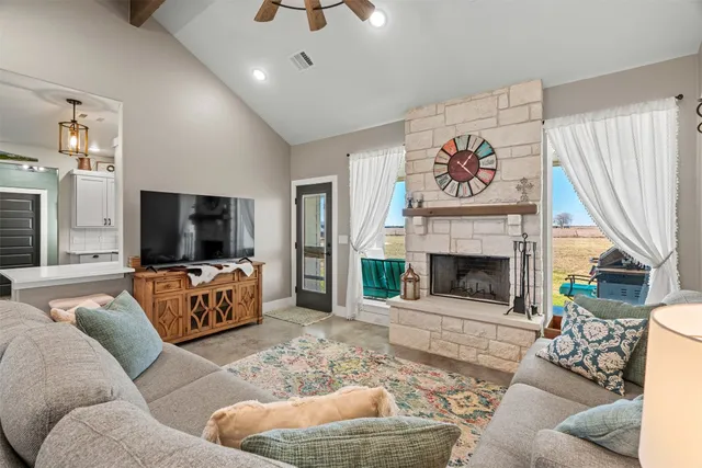 a living room with furniture a flat screen tv and a fireplace