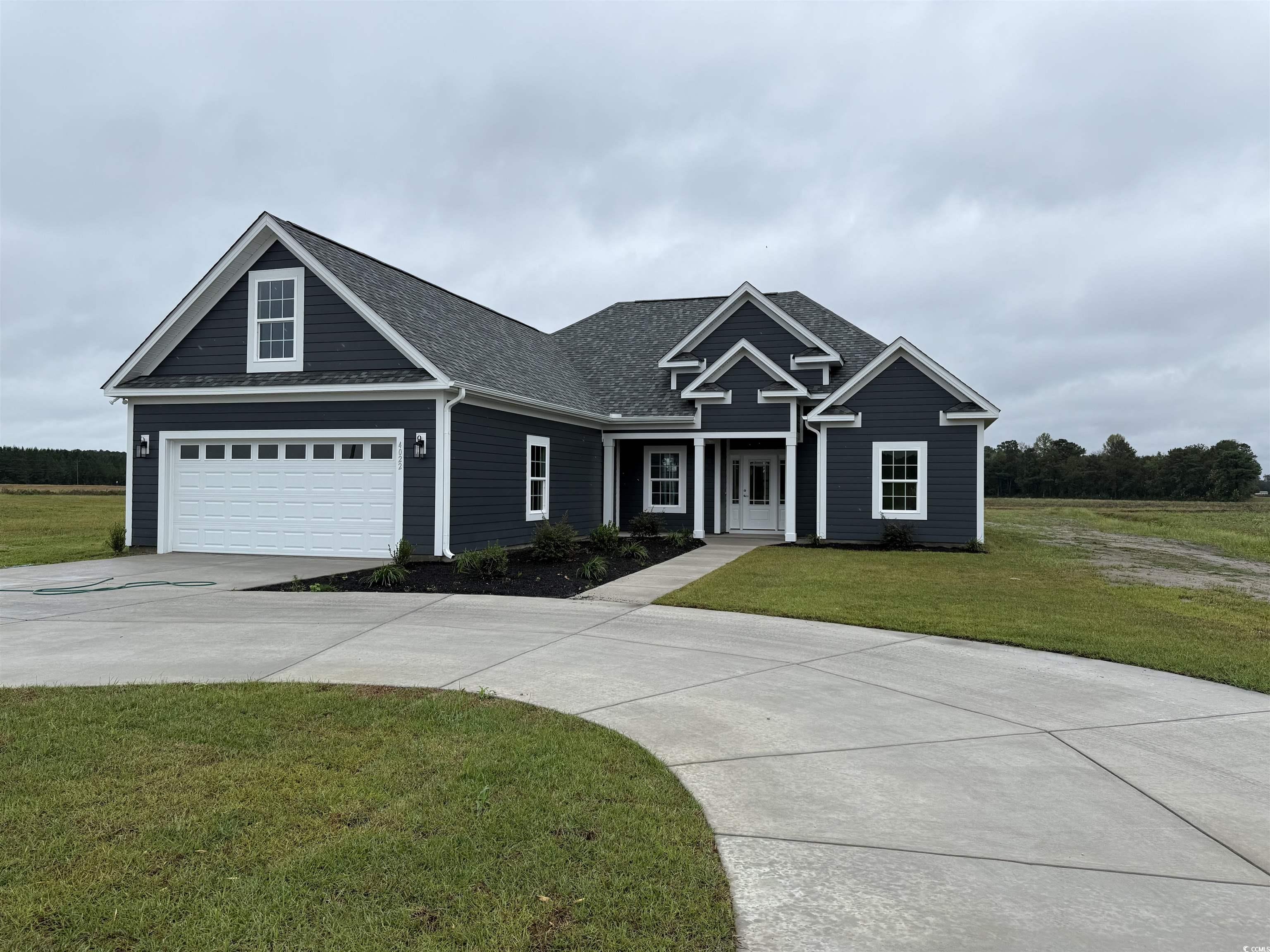View of front of house featuring a front yard, driveway, a garage, and a shingled roof
