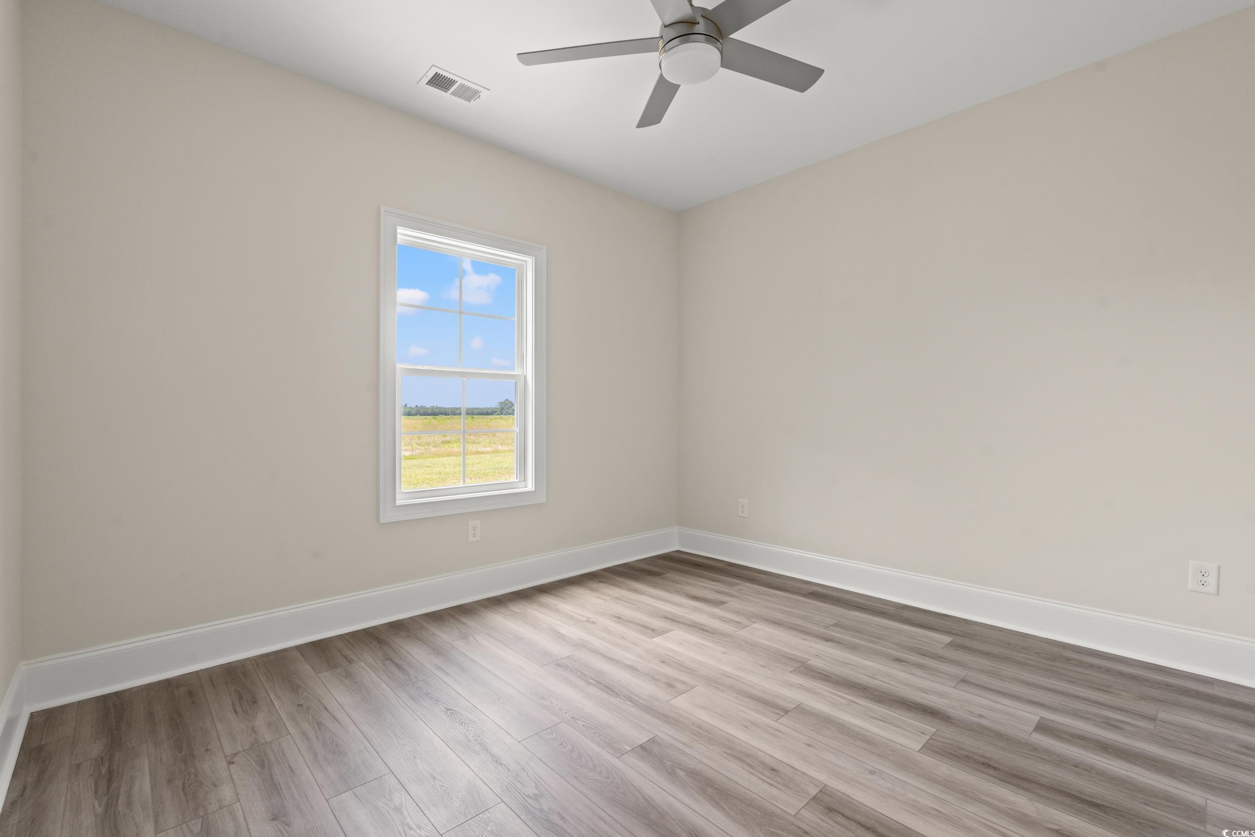4022 Macks Road Aynor, SC 29511 - Photo 16 of 35 Empty room featuring wood finished floors, baseboards, and a ceiling fan