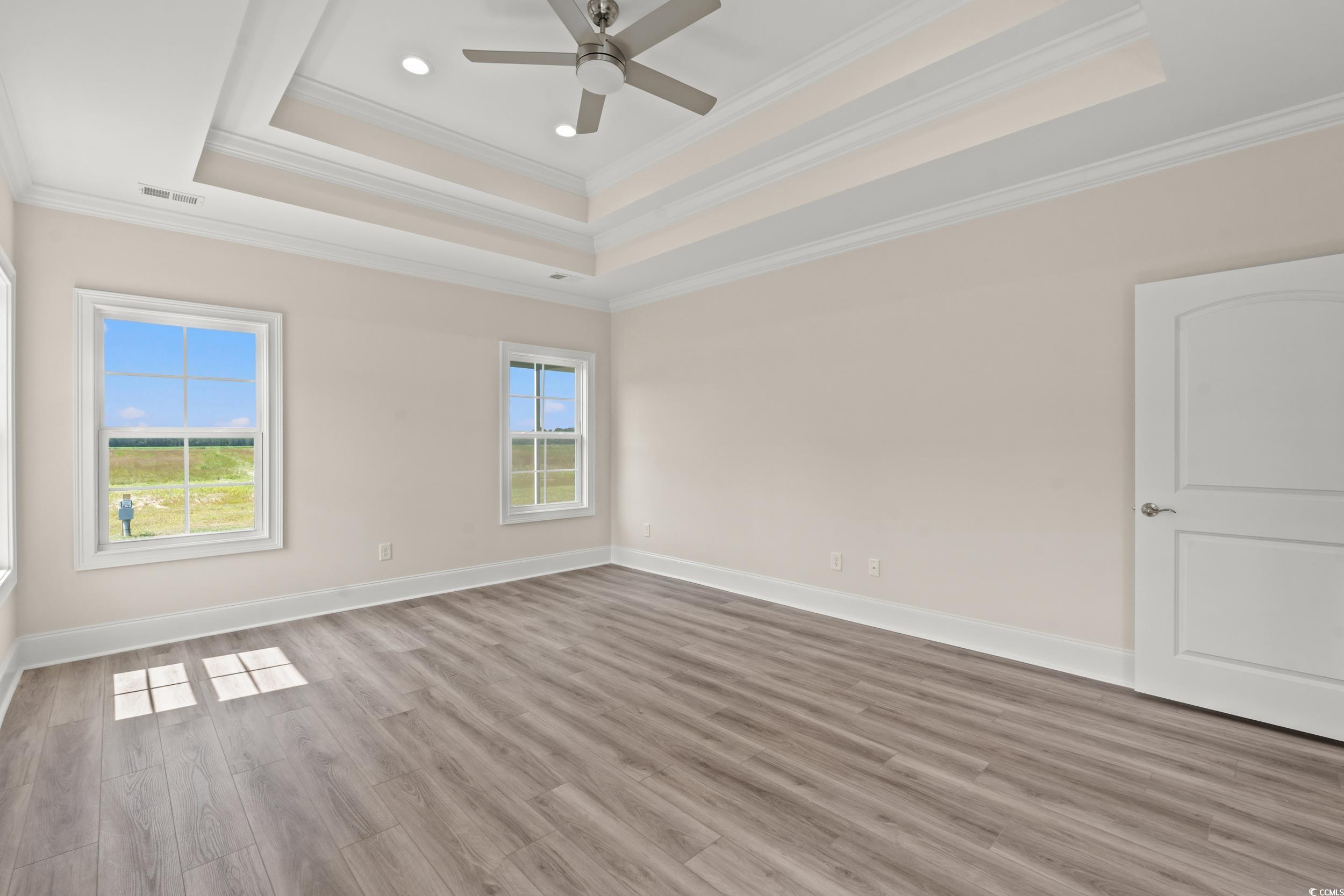 4022 Macks Road Aynor, SC 29511 - Photo 9 of 35 Spare room with a raised ceiling, crown molding, wood finished floors, ceiling fan, and baseboards