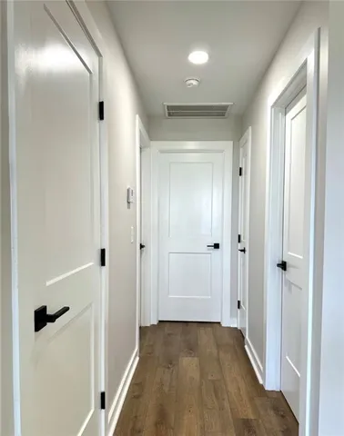 a view of a hallway with wooden floor