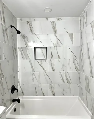 a bathroom with a bathtub and shower