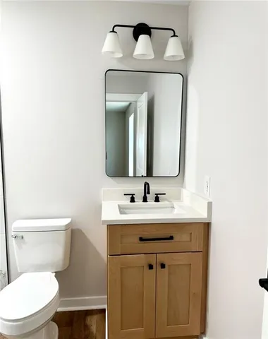 a bathroom with a toilet sink and mirror