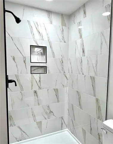 a bathroom with a shower and a mirror