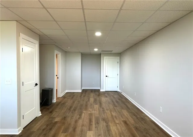 a view of a big room with wooden floor and windows