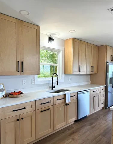 a kitchen with stainless steel appliances granite countertop a sink a stove and cabinets