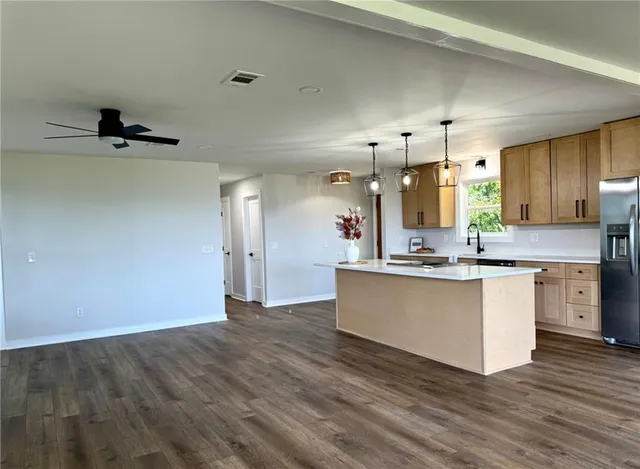 a large kitchen with granite countertop a white stove top oven and a dishwasher with wooden floor