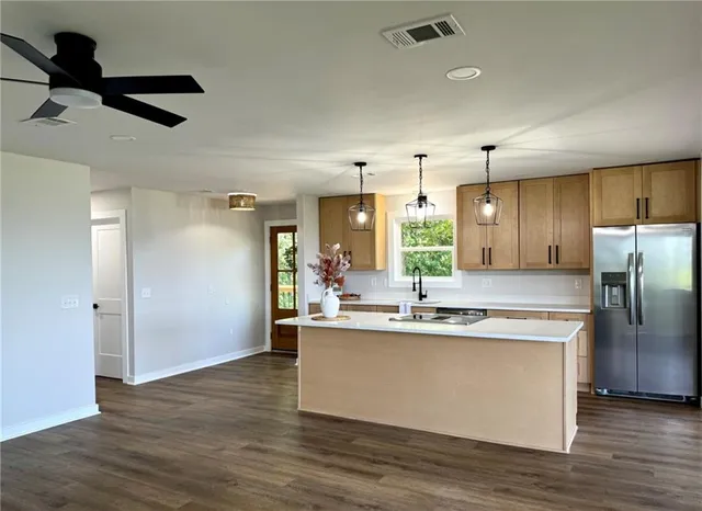 a kitchen with stainless steel appliances granite countertop a sink a stove and a refrigerator