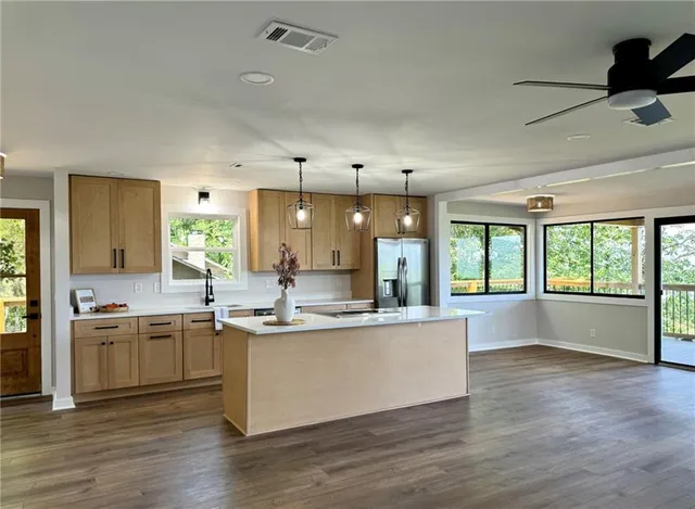 a large kitchen with kitchen island a sink and a large window