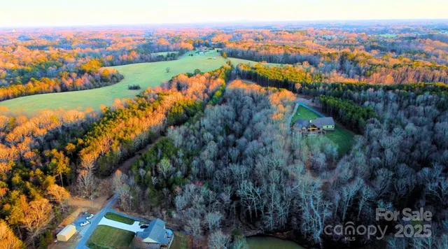 an aerial view of lake residential house with outdoor space and trees around