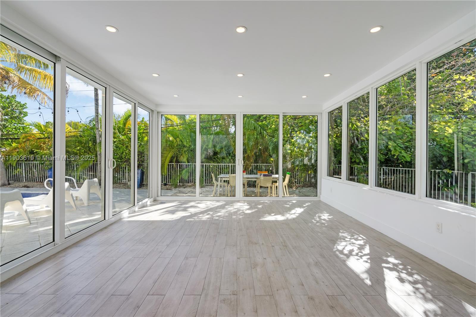 525 Ridgewood Road Key Biscayne, FL 33149 - Photo 25 of 58 a view of backyard with large windows and wooden floor