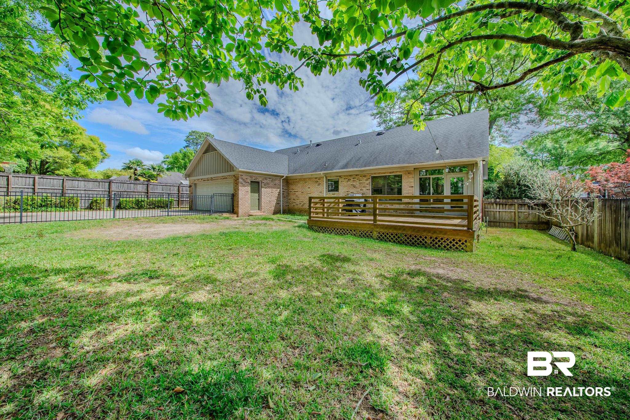 1250 Savannah Drive Mobile, AL 36609 - Photo 35 of 35 Back of house with a fenced backyard, a wooden deck, an attached garage, and brick siding