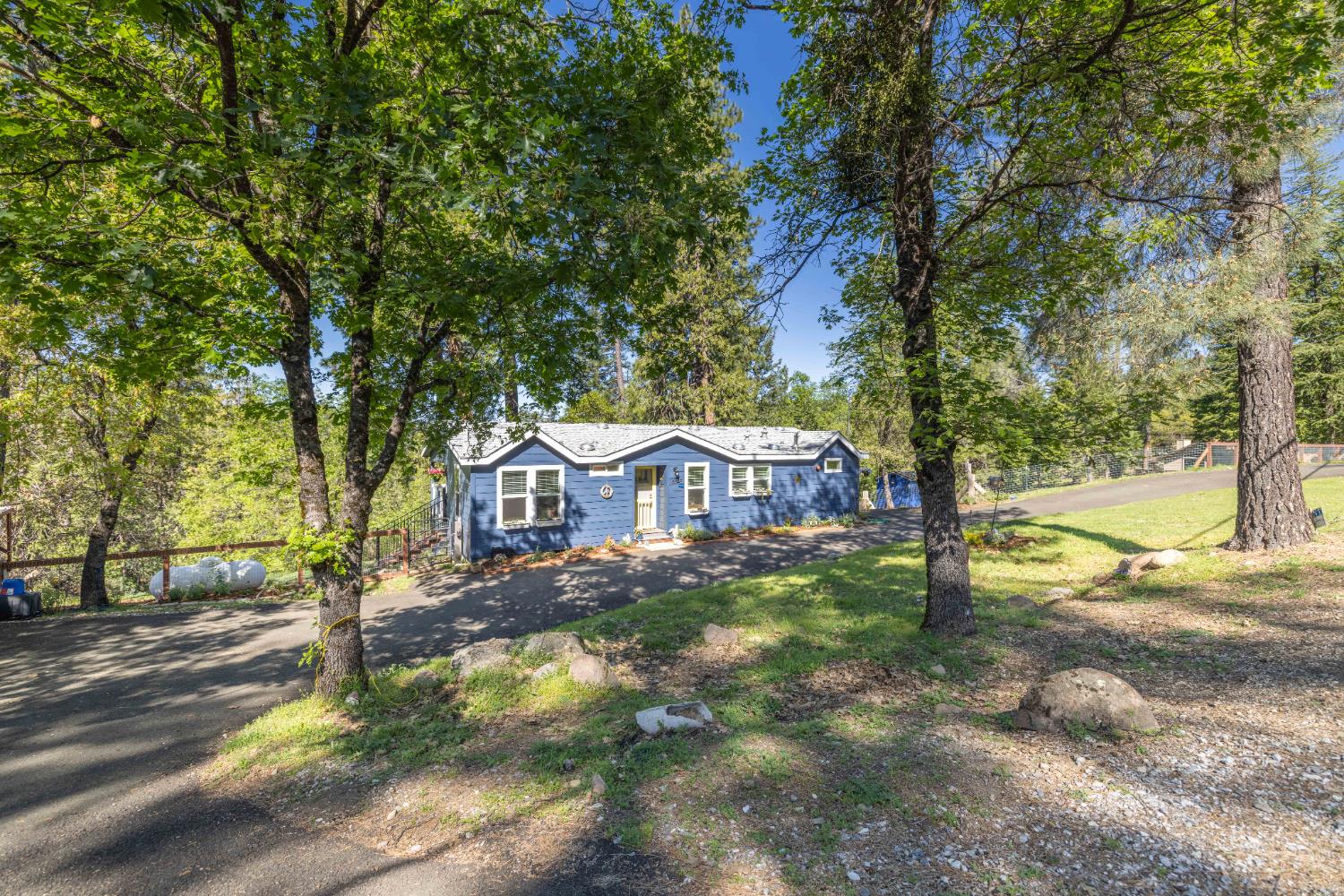 5015 Shooting Star Road Pollock Pines, CA 95726 - Photo 24 of 44 a front view of a house with a yard and large tree