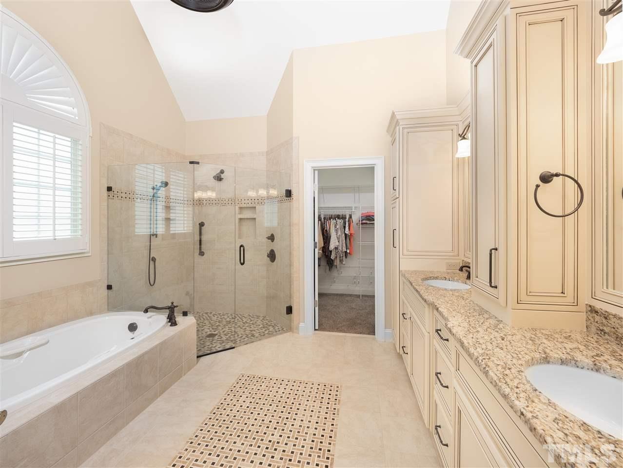 2512 Brook Crossing Circle Raleigh, NC 27606 - Photo 11 of 28 a bathroom with a granite countertop tub sink a shower and a mirror