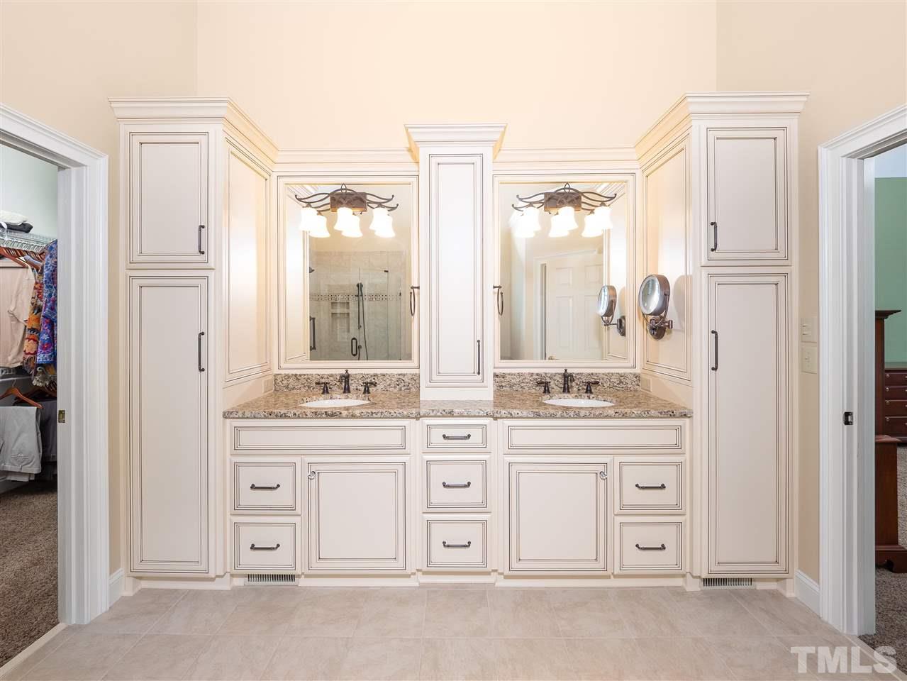 2512 Brook Crossing Circle Raleigh, NC 27606 - Photo 12 of 28 a bathroom with a double vanity sink a mirror a bathtub and