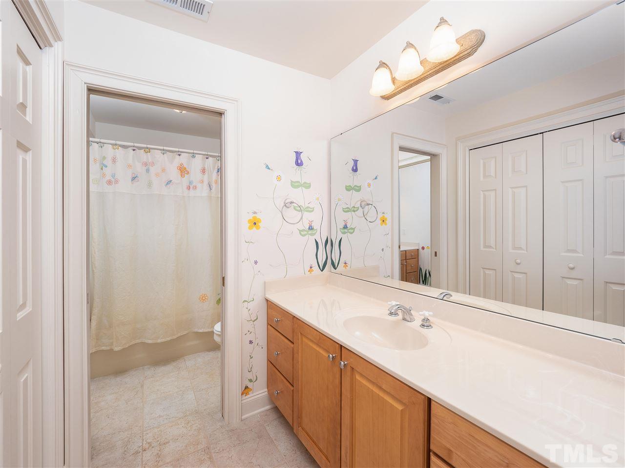2512 Brook Crossing Circle Raleigh, NC 27606 - Photo 17 of 28 a bathroom with a sink vanity granite tub shower and a mirror