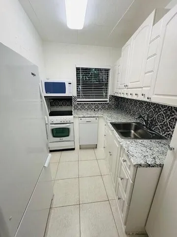 a kitchen with a stove top oven and cabinets