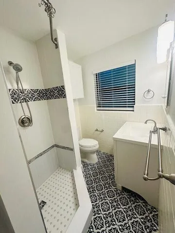 a bathroom with a sink a toilet and shower