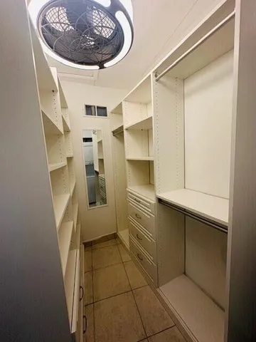 a kitchen with a refrigerator and white cabinets