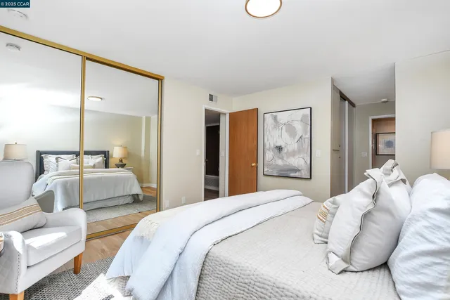 a bedroom with a large bed and glass walk in closet