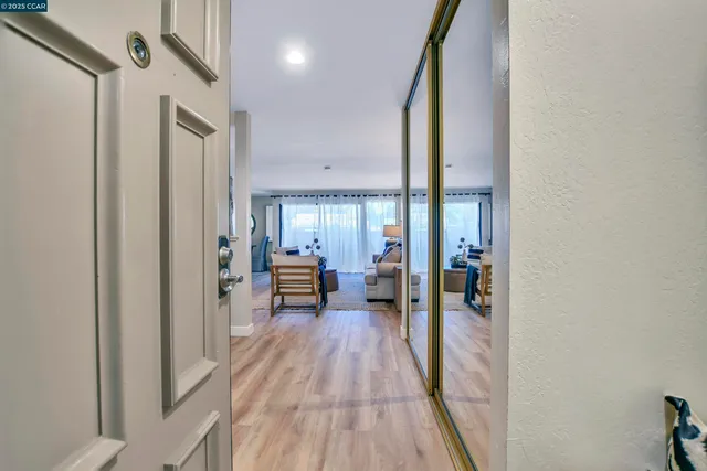 a view of a hallway with a livingroom and furniture