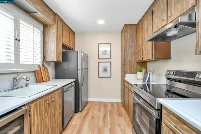 a kitchen with stainless steel appliances granite countertop a sink stove and refrigerator