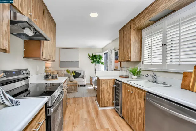 a kitchen with a sink a counter top space appliances and cabinets