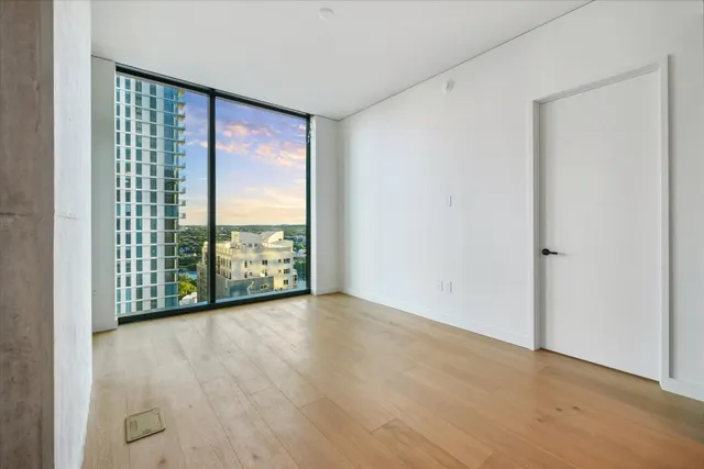 a view of an empty room with glass door and balcony