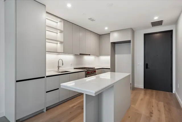 a kitchen with stainless steel appliances granite countertop a refrigerator a sink and a stove