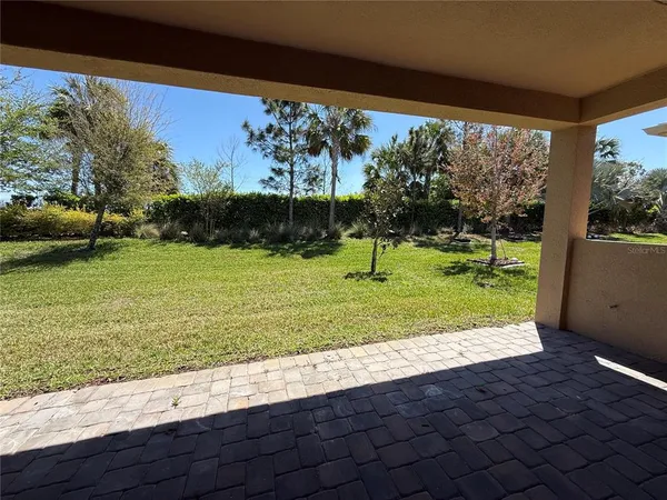 a view of a grassy field with trees in the background