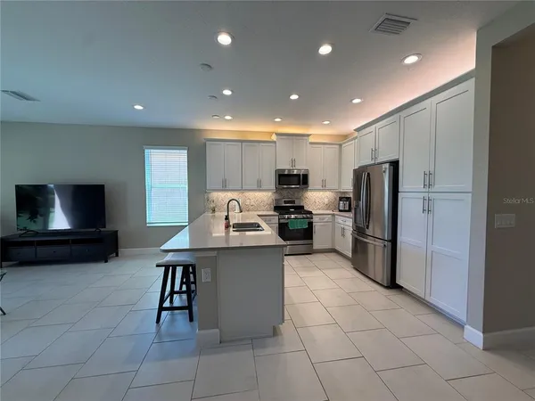 a kitchen with stainless steel appliances granite countertop a refrigerator sink and cabinets