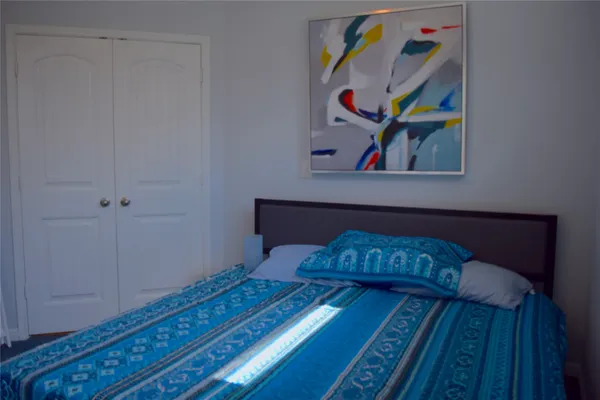 a bedroom with a bed and painting on the wall