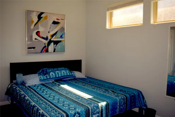a bedroom with a bed and painting on the wall