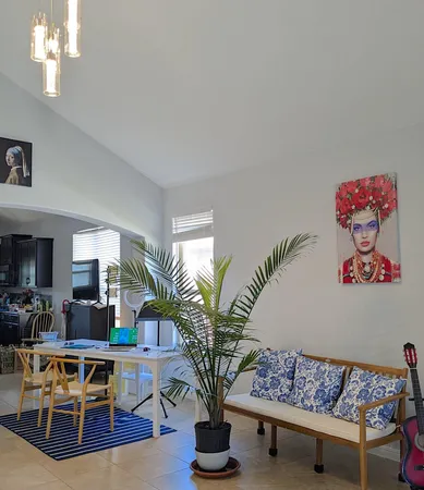 a living room with furniture a chandelier and a potted plant