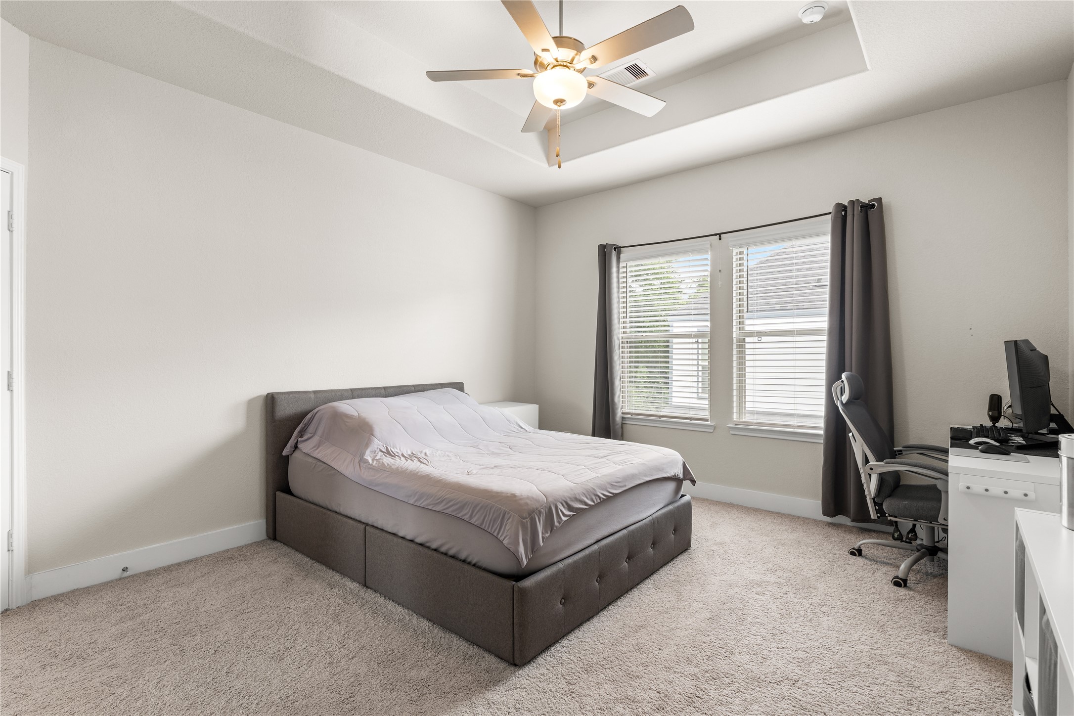 4001 Baja Lane Houston, TX 77045 - Photo 15 of 27 Even with a dedicated workspace and full bedroom furnishings, the primary suite retains a remarkable sense of openness, highlighting the thoughtful proportions of the room.