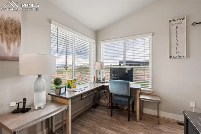 a view of a workspace with furniture and a window