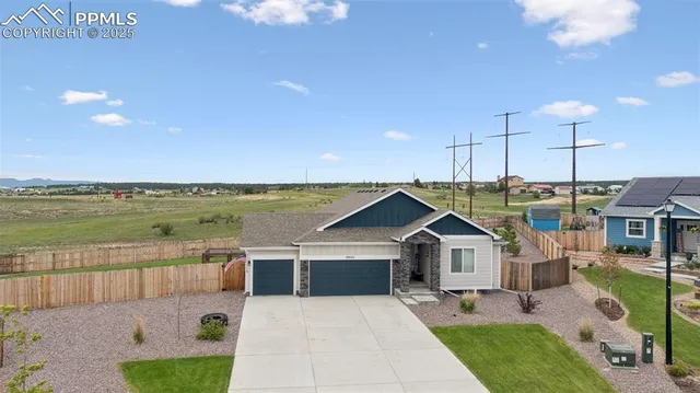 a front view of a house with a garden and lake view