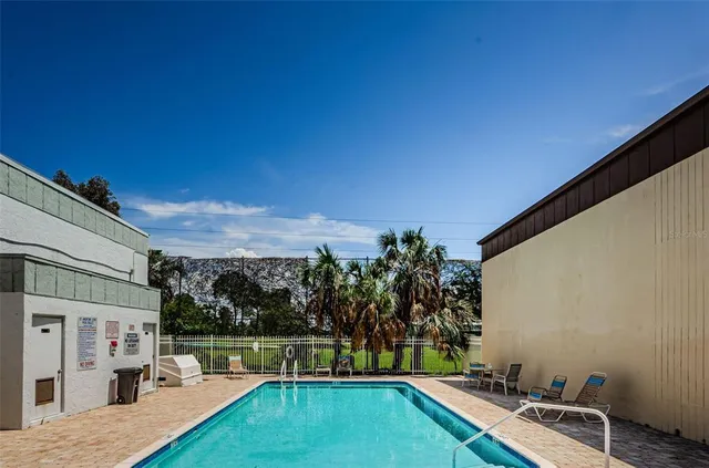 a view of a swimming pool with a patio and a yard