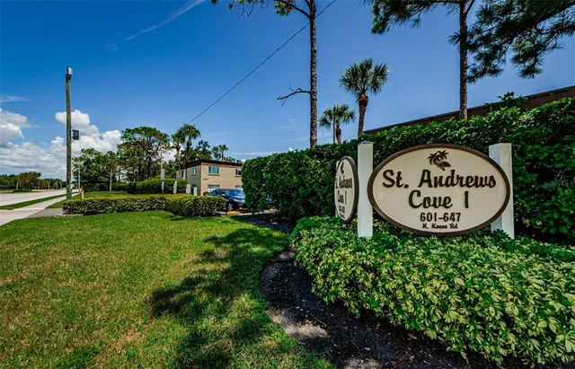 a view of a sign in a yard with potted plants