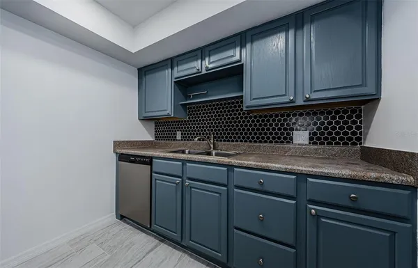 a kitchen with granite countertop cabinets sink and stainless steel appliances
