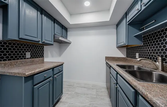 a kitchen with a sink a stove and cabinets